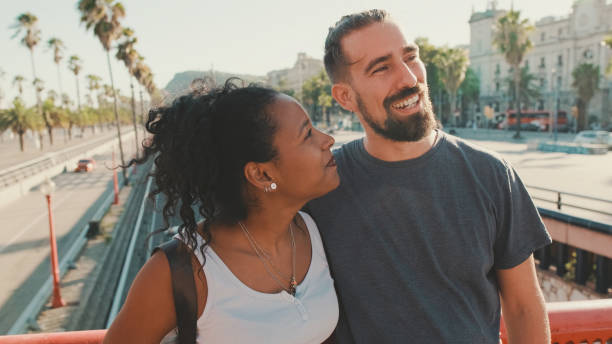 istock Close-up of happy interracial couple talking while standing on bridge 1455299872
