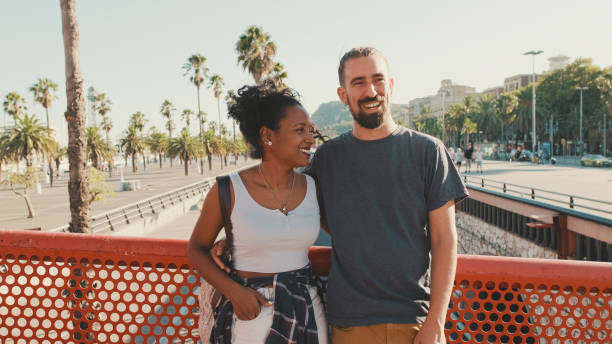 istock Close-up of happy interracial couple talking while standing on bridge 1455299881