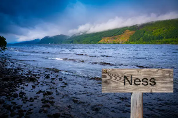 Loch Ness with wooden sign photomount in Scotland Highlands UK famous for the Nessie monster sightings.