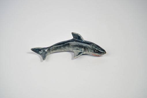 Miniature shark handmade from clay on a white background.