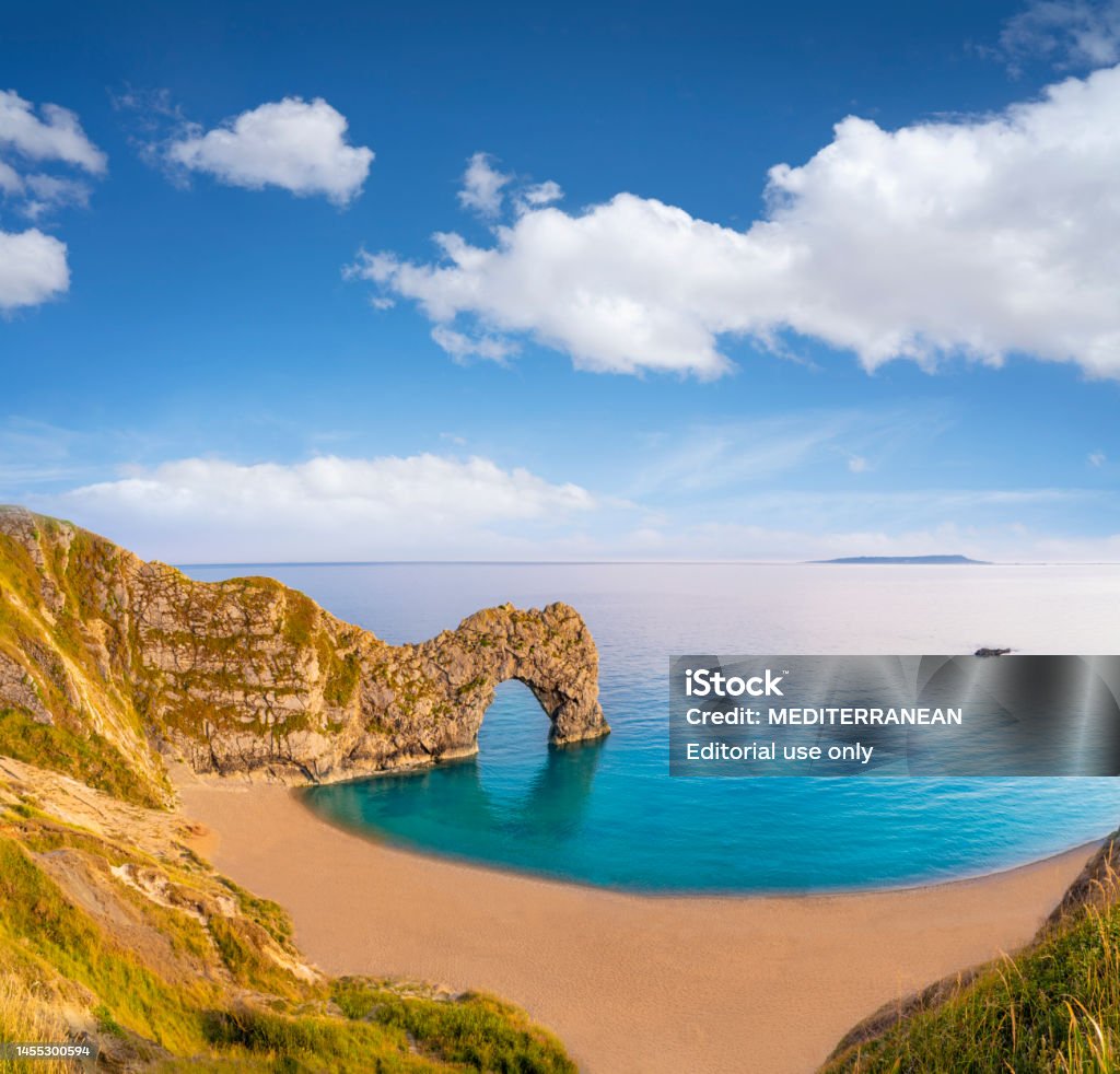 Durdle Door is a natural limestone arch on the Jurassic Coast in Dorset beach, England Durdle Door is a natural limestone arch on the Jurassic Coast in Dorset beach, England, UK Bay of Water Stock Photo