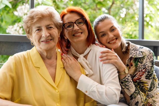 istock Three generations of women cuddling and smiling joyfully at camera 1455302161
