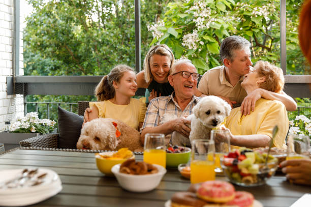 istock Three generation family cuddling and bonding during a celebratory party on the balcony 1455302352