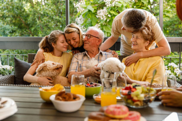 Three generation family cuddling and bonding during a celebratory party on the balcony