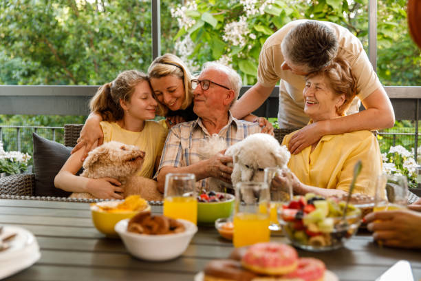 Three generation family cuddling and bonding during a celebratory party on the balcony stock photo