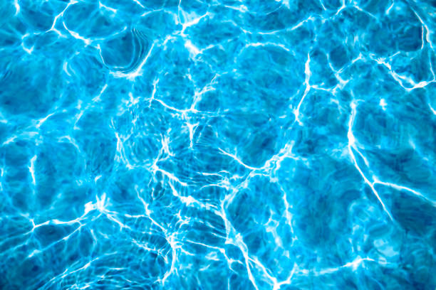 istock Defocused blurred transparent blue colored clear calm water surface texture with splashes and bubbles. Trendy abstract nature background. Water waves in sunlight with copy space. 1455302663