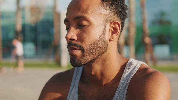 istock Young bearded male athlete is resting after training sitting on bench on modern background 1455304538