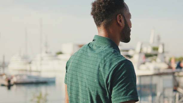istock Young laughing happy man in harbor with yachts on background 1455304878