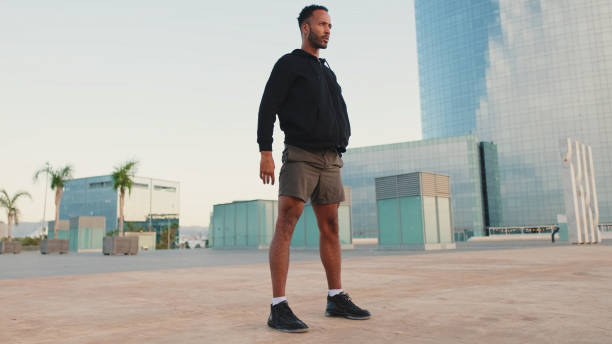 istock Young bearded male athlete doing workout, squats and jumping on the waterfront 1455304892