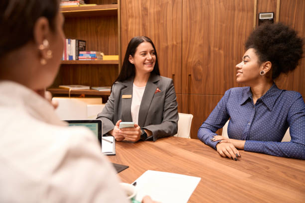 istock Clinic worker sitting next to African American lady 1455304959