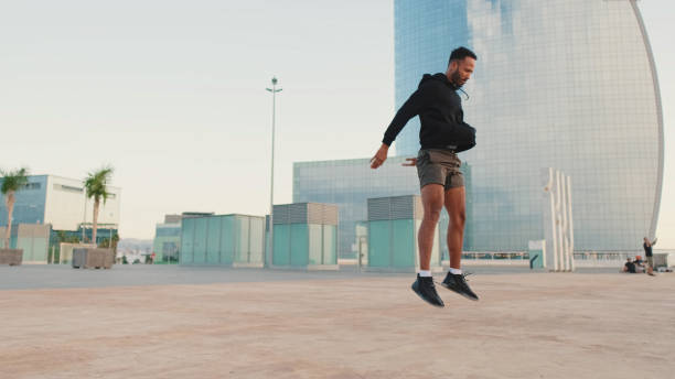 istock Young bearded male athlete doing workout, squats and jumping on the waterfront 1455305206