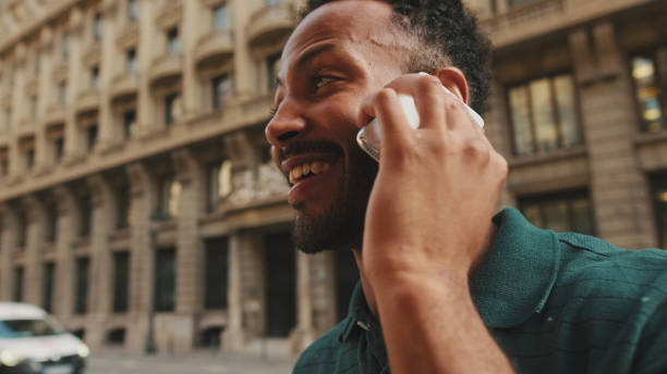 istock Young man talking on mobile phone while standing on the street next to the road 1455305252