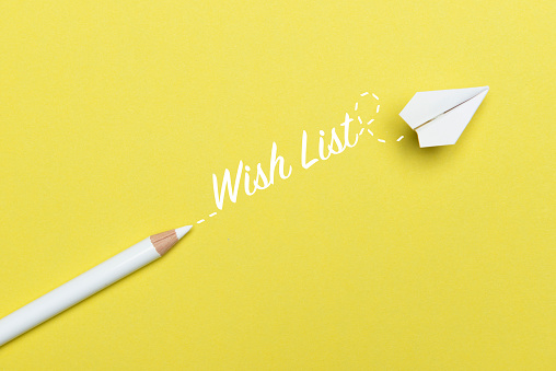 White pencil with Wish List text and a white paper plane on yellow background.