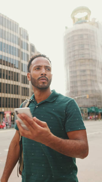istock Young man tourist uses map app on mobile phone on modern buildings background 1455305474