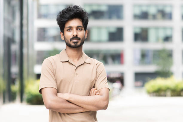 istock Handsome smiling young man with crossed arms in a city 1455306580