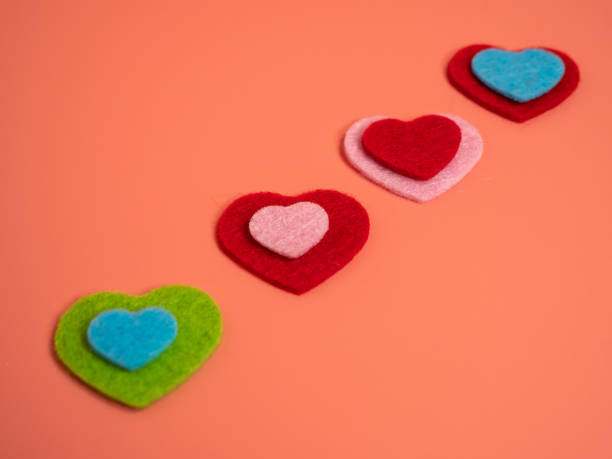 istock Heart of different colors on a pink background. 1455306612