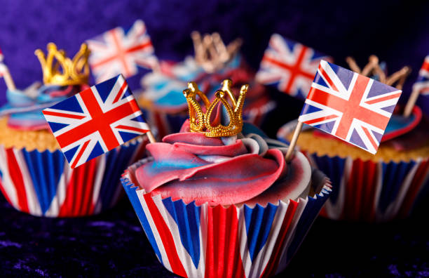Royal Coronation Cupcakes to Celebrate the Coronation of King Charles III Luxury royal cupcakes, with purple velvet background, all cupcakes have a metal crown as a topper, including the royal crown, union jack flags decorate the cupcakes, coronation photos stock pictures, royalty-free photos & images