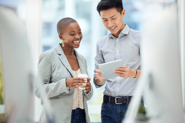 istock Happy, business people and digital tablet planning in office with creative, design and team discuss online project. Planning, strategy and asian man share mission, vision and goal with black woman 1455307747