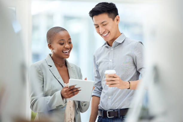 tablette, sourire et employés parlant d’affaires sur internet, de partenariat en ligne et de lecture d’un e-mail ensemble au travail. travailleurs du marketing ayant une idée de collaboration créative sur la technologie - collègue de bureau photos et images de collection