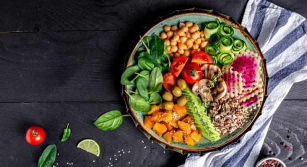 istock Buddha Bowl with Quinoa, Avocado, mushrooms, cucumber, chickpeas, spinach, tomatoes, vegetables salad. Clean eating, dieting, vegan food concept. top view 1455308572