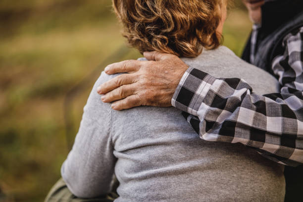 istock Affectionate senior man embracing his loving wife while sitting outside in thier back yard 1455309160