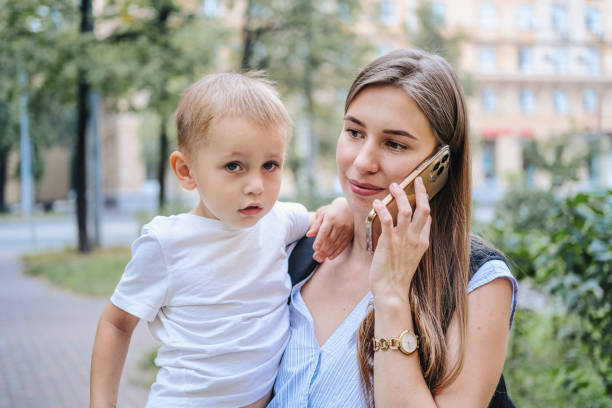 istock Young mother uses smartphone 1455312763