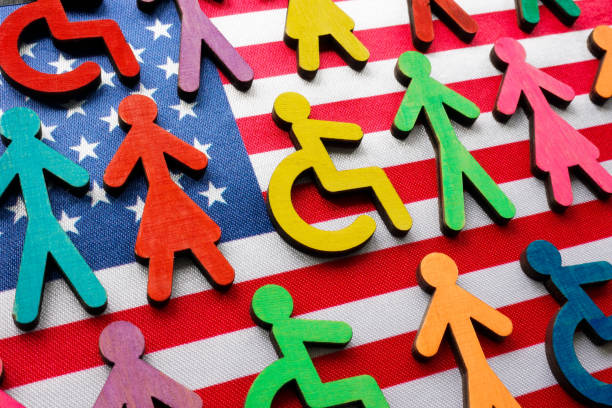 US flag and multi-colored figures with the symbol of a disability person. stock photo