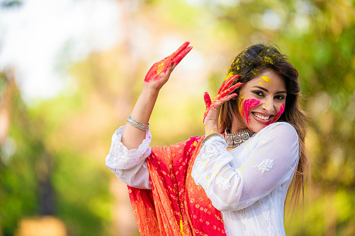 A beautiful girl celebrating holi with colours at park. The spring festival, also known as Festival of Colours or Holi, is an ancient Hindu religious festival and mainly celebrated in India