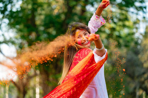 feliz joven hermosa jugando con los colores con motivo del festival holi - holi fotografías e imágenes de stock