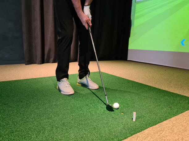 giocatore di golf che gioca a golf al chiuso sul primo piano del simulatore di golf - simulatore foto e immagini stock