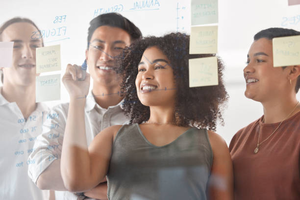 istock Business people, writing or sticky notes planning in teamwork collaboration, kpi strategy or company finance growth target. Smile, happy or worker diversity with schedule of global company brand goal 1455317576