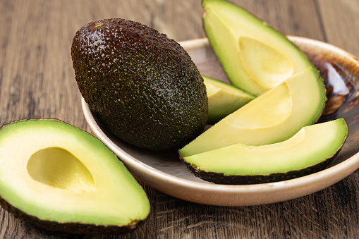 Haas avocados on green background, top view, copy space. Healthy fresh organic avocado closeup.