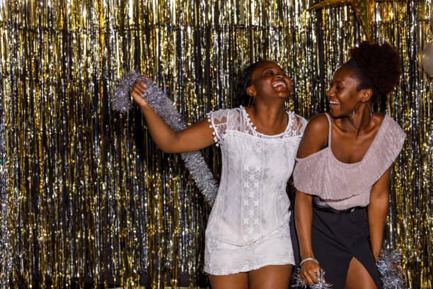 istock Girlfriends dancing and playing with silver tinsel garland when celebrating New Year's eve 1455320989