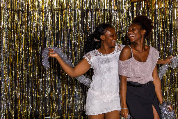 istock Girlfriends dancing and playing with silver tinsel garland when celebrating New Year's eve 1455320990
