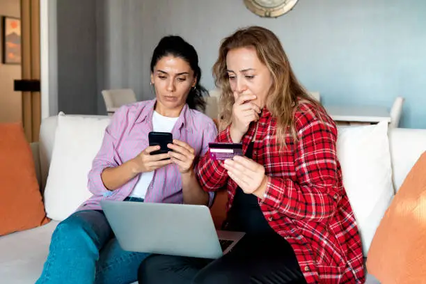 Photo of Stressed upset woman holding bank card and being surprised