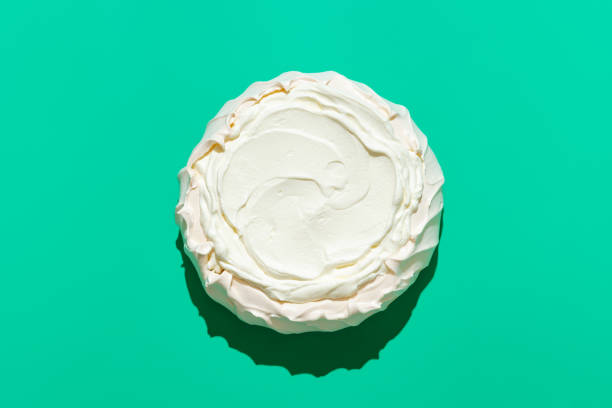 Pavlova cake in bright light, isolated on a green background stock photo