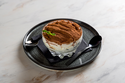 classic tiramisu dessert on a white marble table