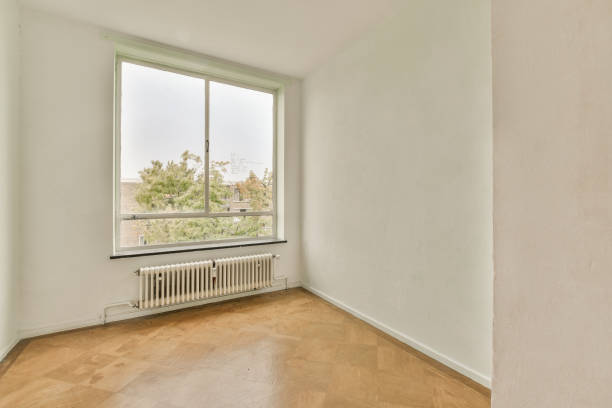 istock an empty room with a large window and wooden floors 1455325225