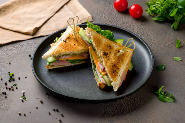 istock ham and cheese sandwich on black plate on brown table 1455325421