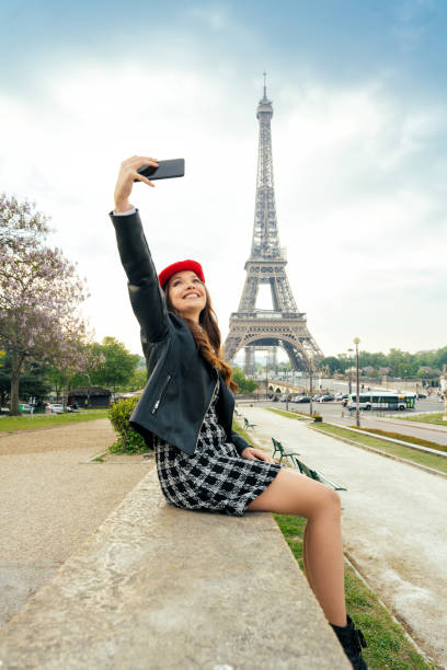 Beautiful young woman visiting paris and the eiffel tower. Parisian girl with red hat and fashionable clothes having fun in the city center and landmarks area