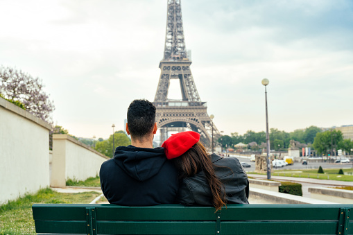 cheerful happy couple in love visiting Paris city centre and Eiffel Tower . american tourists travelling in Europe and dating outdoors