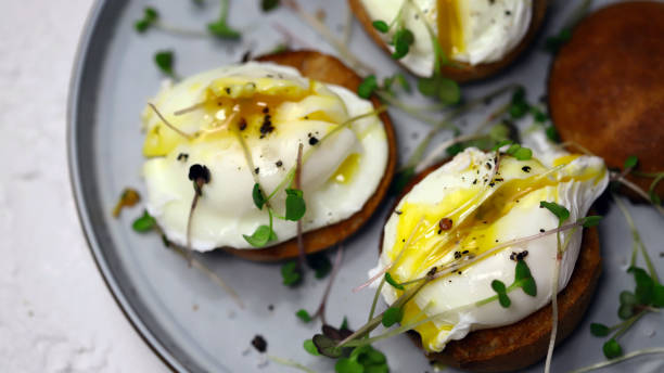 istock Poached eggs with microgreens on a crispy bun on a plate. 1455330959