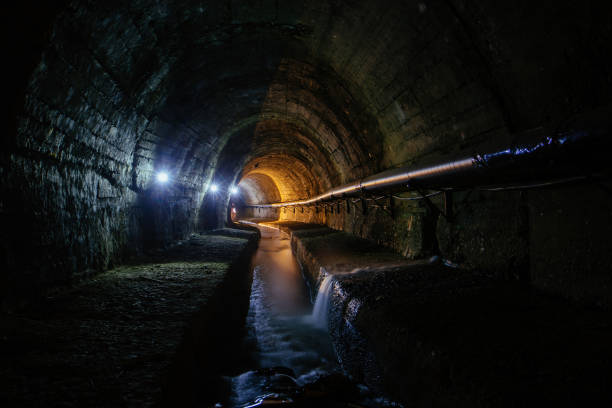 istock Underground vaulted urban sewer tunnel with dirty sewage 1455331815