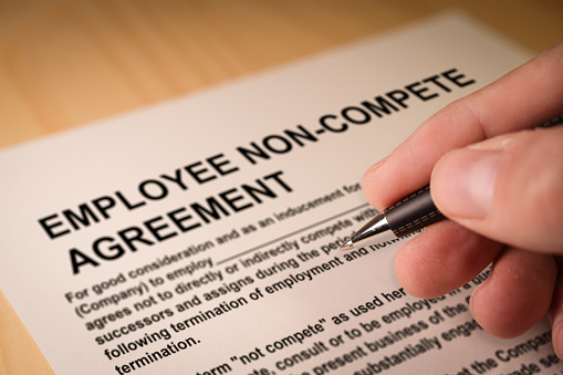 Man signing an employee Non-compete agreement. Selective focus