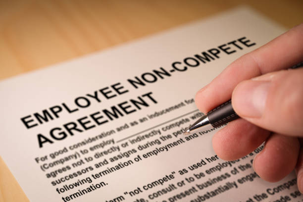 Man signing an employee Non-compete agreement stock photo