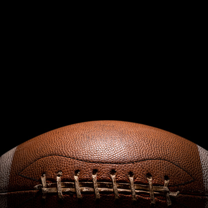 A football on a tee on a yard line under lights at night
