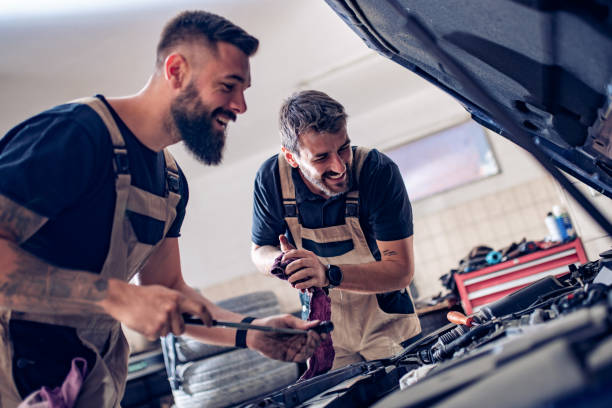 Auto mechanics check the oil in the engine stock photo