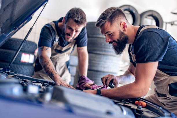 Auto mechanics check the oil in the engine stock photo