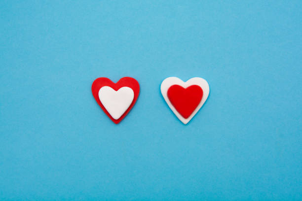 Red and white hearts on a pastel blue background. Minimal creative concept. A symbol of motherly love. Valentine's Day.