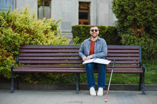hombre ciego leyendo tocando libro braille - outdoors book reading accessibility fotografías e imágenes de stock